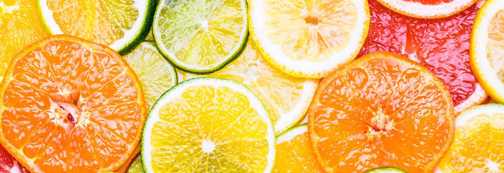 Fresh citrus fruits sliced assortment top view flat lay background.